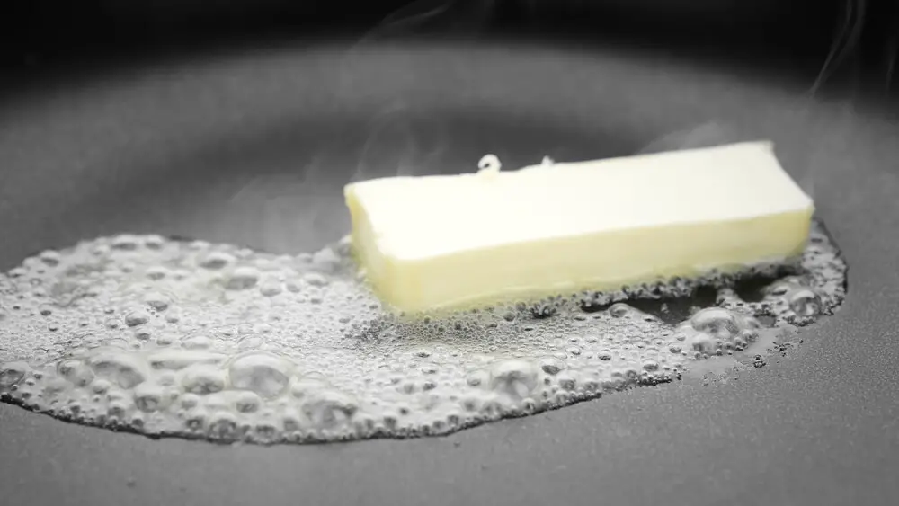 butter melting in a frying pan due to applying heat. 