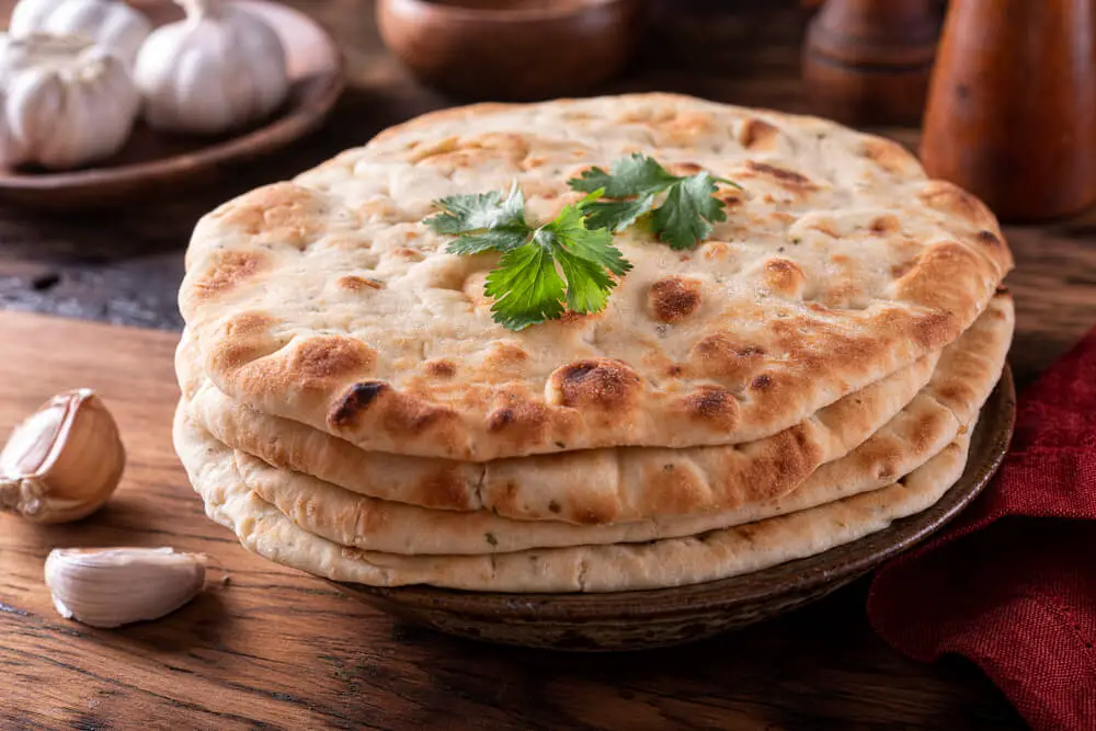 garlic-naan stacked on a plate