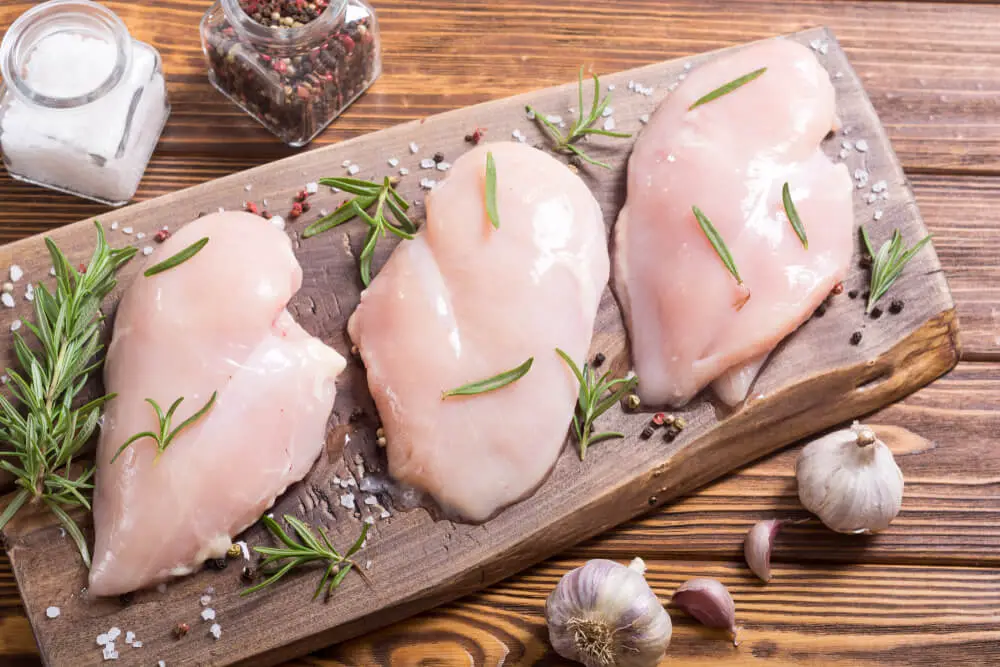 raw chicken breast placed on a chopping board