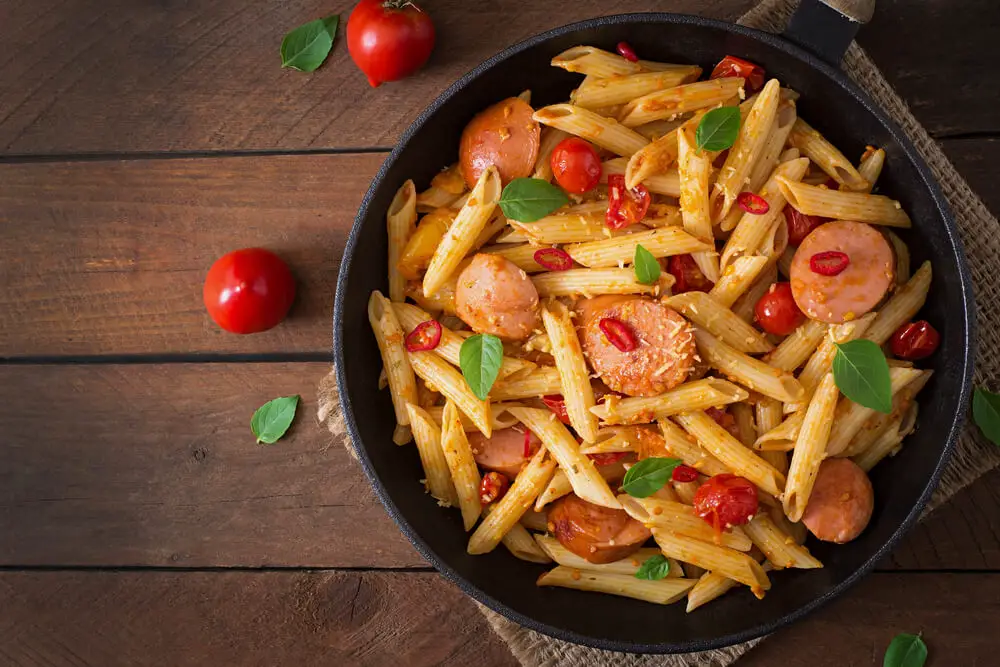 pasta with sausages in a frying pan