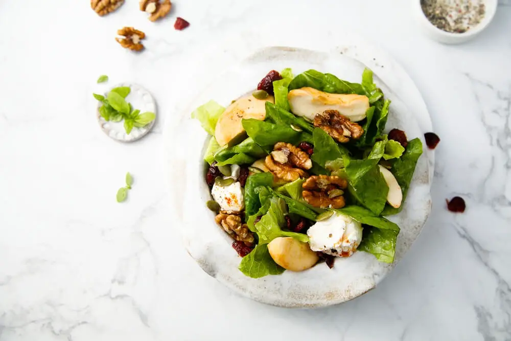 top view of goat cheese salad presented in a white bowl