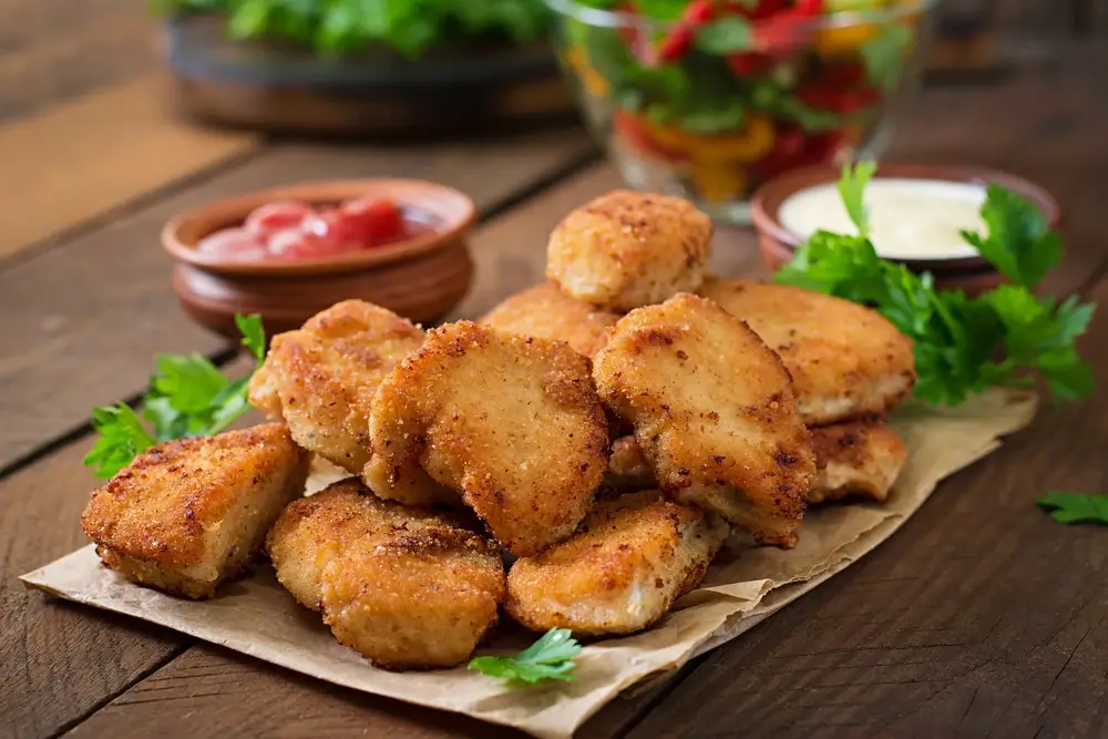closeup view of chicken nuggets on a wooden table